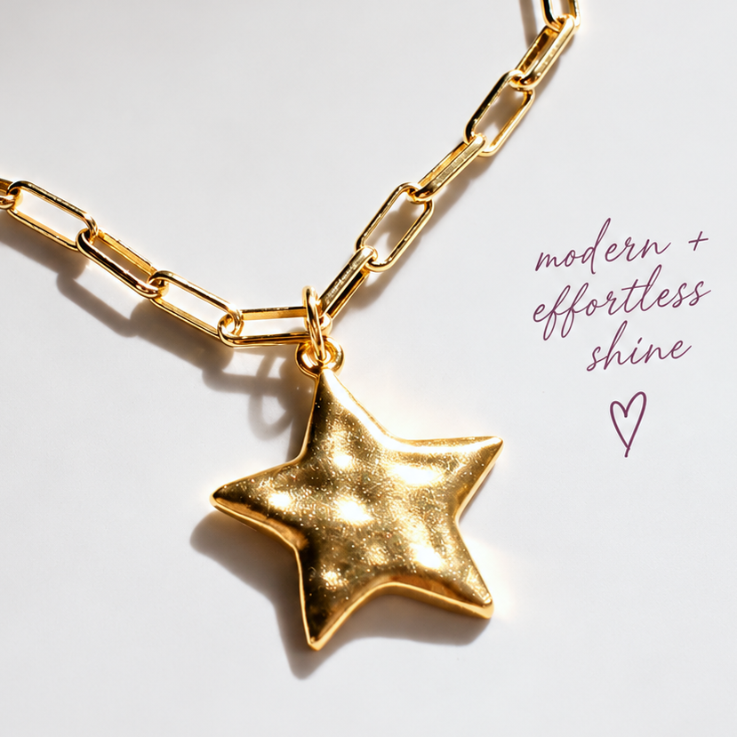 Gold star pendant necklace with a chunky link chain on a light gray background, featuring branding text 'THE SILVER WREN' and marketing copy.