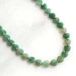 Green beaded necklace on a white background