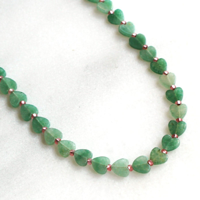 Green beaded necklace on a white background