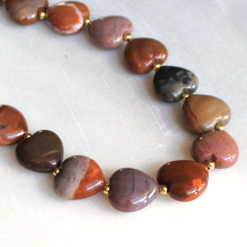 Necklace with brown and black beaded stones on a white surface