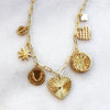 Gold necklace with various pendants on a white background