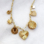 Gold necklace with various pendants on a white background