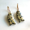Pair of fish-shaped earrings with a spotted pattern on a white background