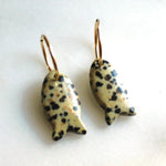 Pair of fish-shaped earrings with a spotted pattern on a white background
