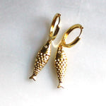 Gold fish-shaped earrings on a white background