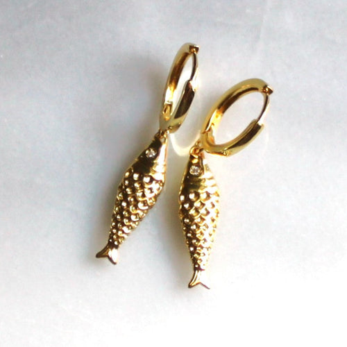 Gold fish-shaped earrings on a white background