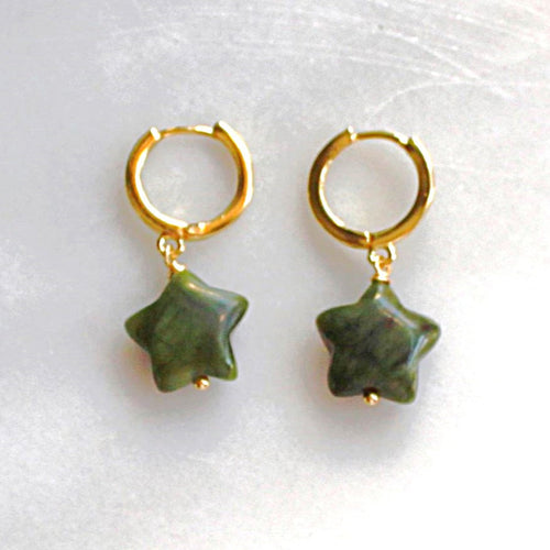 Gold hoop earrings with green star-shaped charms on a white background