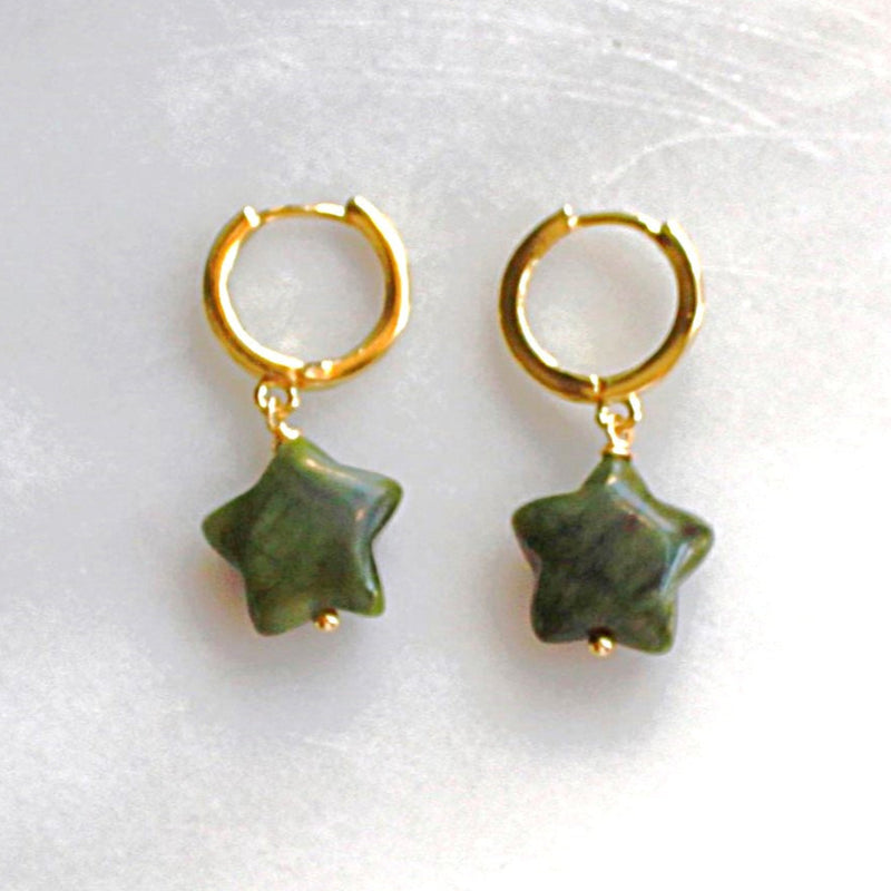 Gold hoop earrings with green star-shaped charms on a white background