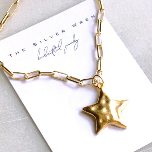 Gold chain necklace with a star pendant on a white card with 'The Silver Wren' branding.