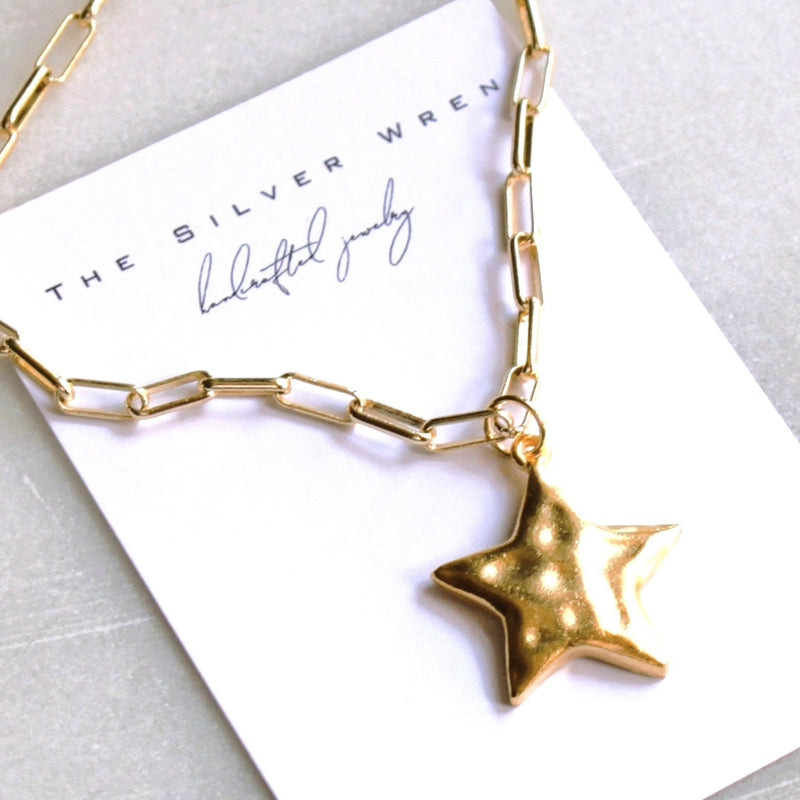 Gold chain necklace with a star pendant on a white card with 'The Silver Wren' branding.