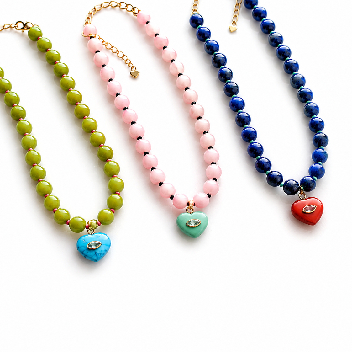 Three beaded necklaces with gold-tone chains and heart-shaped pendants in blue, green, and red, displayed on a clean white background.